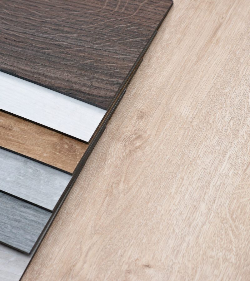 Sample catalog of luxury vinyl floor tiles with a new interior design for a house or floor on a light wooden background. Copy space.